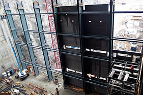 L’installation de panneaux préfabriqués servant de coffrage pour le mur aval de la centrale Romaine-2. Photo de Hydro-Québec