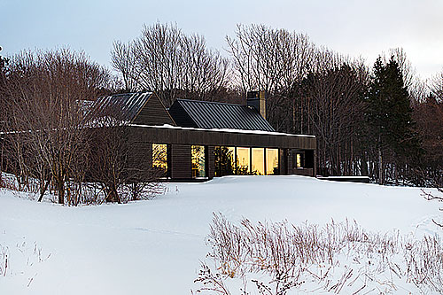 Projet de maison sur le fleuve qui utilise du bois brûlé en guise de parement. Photo : Gracieuseté