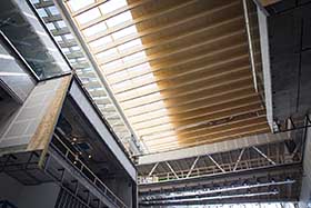 Le plafond de l'atrium est constitué de poutres en bois lamellé-collé qui absorberont les sons - Photo de Laurent Canigiani