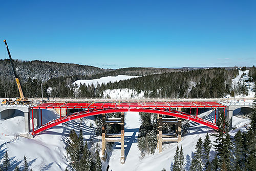 La technique d’installation novatrice privilégiée pour les deux demi-arcs du pont a permis une construction à partir des rives. Crédit : Gracieuseté du MTMD