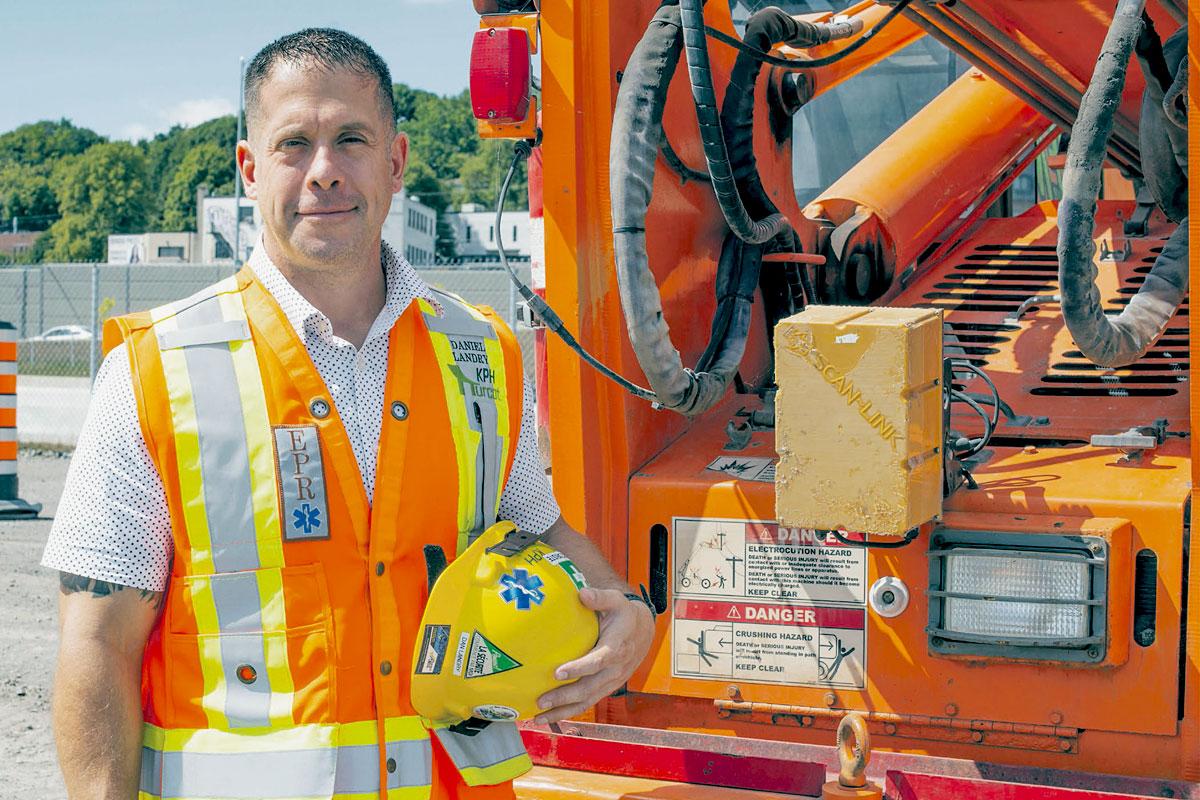 entrepreneur avec ceinture à outils et casque de sécurité devant