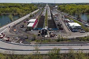 L'embouchure du tunnel, située sur l'île Charron, où on peut voir les poutres paralumes qui ont été installées l'an dernier ainsi que le nouveau bâtiment Saccardo, qui abritera l'équipement nécessaire au bon fonctionnement du tunnel.  Crédit : MTQ