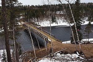 Passerelle à structure de métal avec tablier de bois.